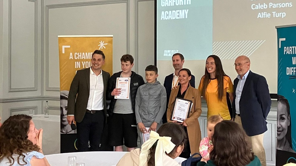 AQA Trustee Mark Allen (right) and Dame Kelly Holmes CEO Martin Talbot (centre, back row), presenting students from Garforth Academy with their certificates